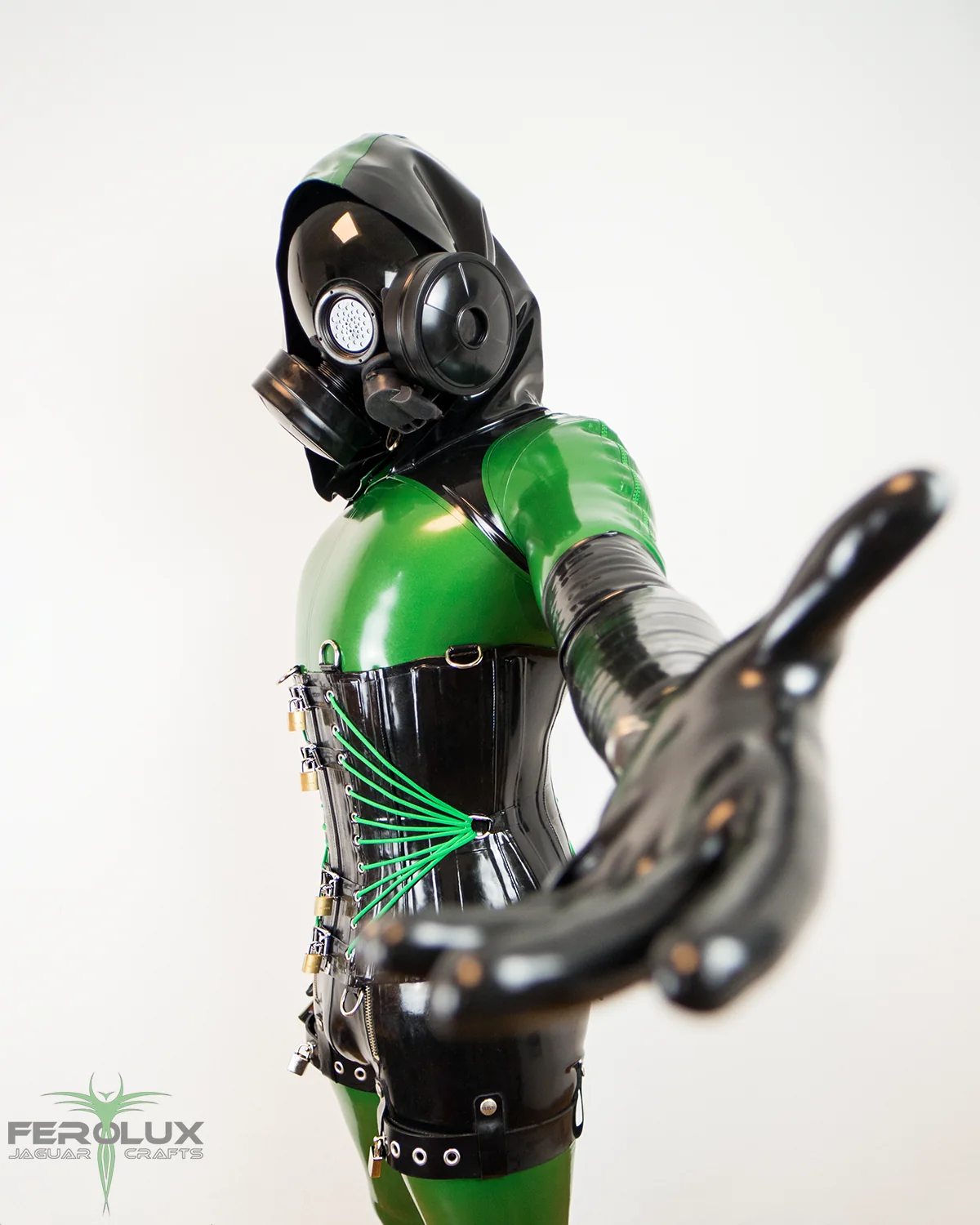 Drohne in grün-schwarzem Latex-Catsuit mit Gasmaske, Korsett und schweren Rubber-Handschuhen
